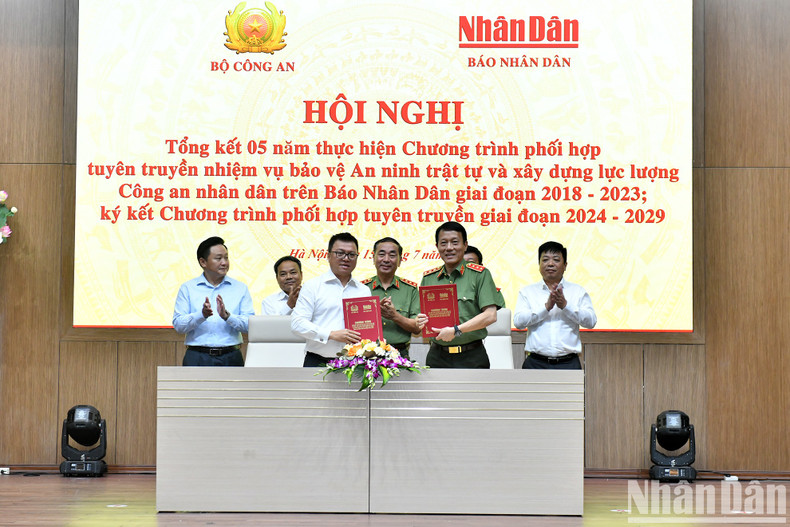El teniente general Luong Tam Quang, ministro de Seguridad Pública y Le Quoc Minh, subjefe de la Comisión de Comunicación y Educación del Comité Central del Partido Comunista de Vietnam, presidente-editor del periódico Nhan Dan y titular de la Asociación de Peridotitas del país, firman el programa de coordinación de propaganda para el período 2024-2029.