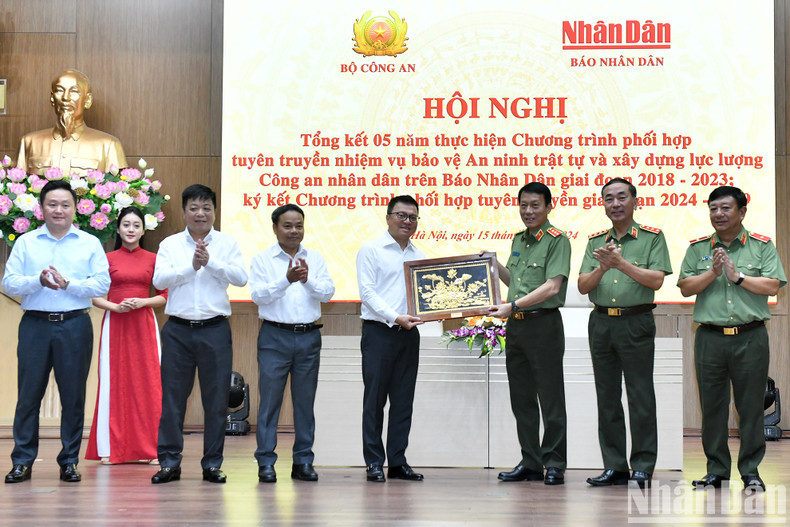 El teniente general Luong Tam Quang, ministro de Seguridad Pública, entrega obsequios al periódico Nhan Dan.