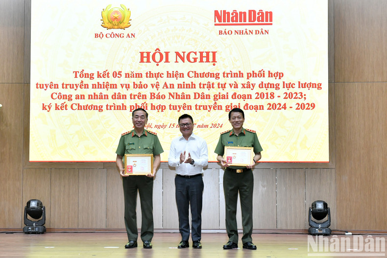 Le Quoc Minh entrega la medalla "Por la causa del periódico Nhan Dan" a los dirigentes del Ministerio de Seguridad Pública.