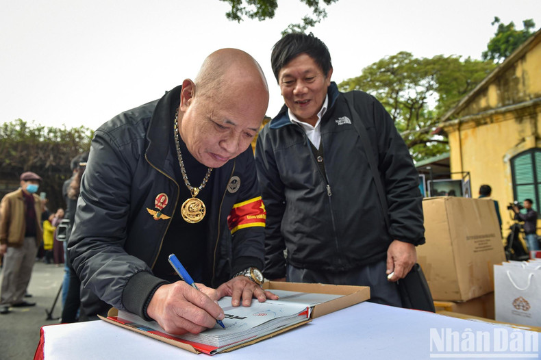 El expiloto del Ejército Popular de Vietnam, Nguyen Hong My, regala a los visitantes libros con su firma. El expiloto del Ejército Popular de Vietnam, Nguyen Hong My, regala a los visitantes libros con su firma.