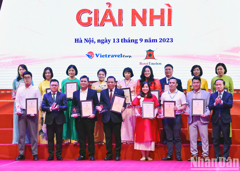 El subjefe permanente de la Comisión para la Movilización de Masas del Comité Central del PCV, Pham Tat Thang y Le Quoc Minh, presidente-editor de Nhan Dan, subjefe de la Comisión de Comunicación y Educación del PCV y presidente de la Asociación de Periodistas del país, otorgan el segundo premio a los ganadores.