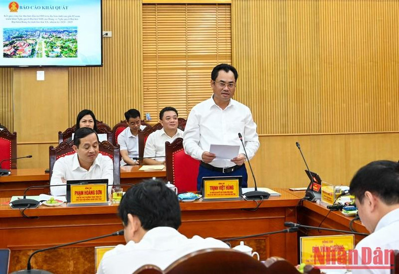 El presidente del Comité Popular de Thai Nguyen, Trinh Viet Hung, presenta un informe sobre la atracción de inversión extranjera directa (IED) en la provincia y el progreso del programa de construcción de la nueva ruralidad en el distrito de Dinh Hoa.