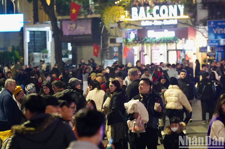 A medida que el reloj marca la medianoche, más y más gente acude a la zona del lago Hoan Kiem.
