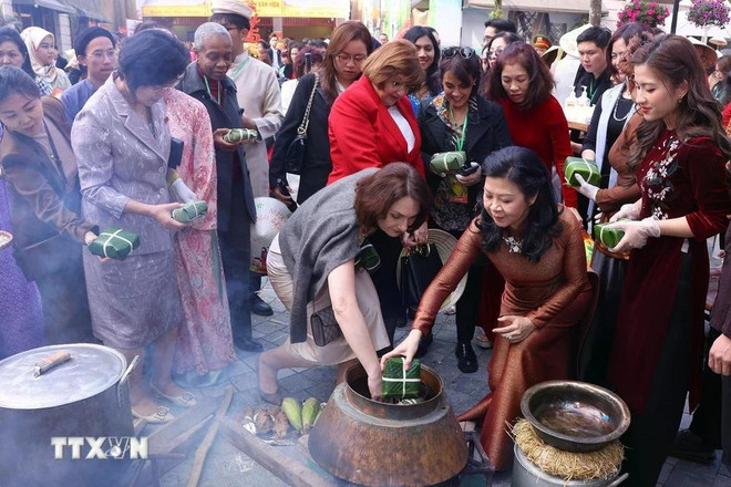 Phuong Ly y los delegados experimentan la elaboración del banh chung. (Fuente: VNA)