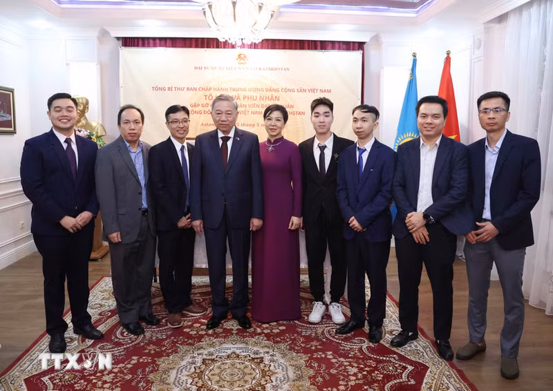 To Lam y su esposa se toman foto de recuerdo con familias de los funcionarios de la Embajada de Vietnam en Kazajistán. (Foto: Thong Nhat/VNA)