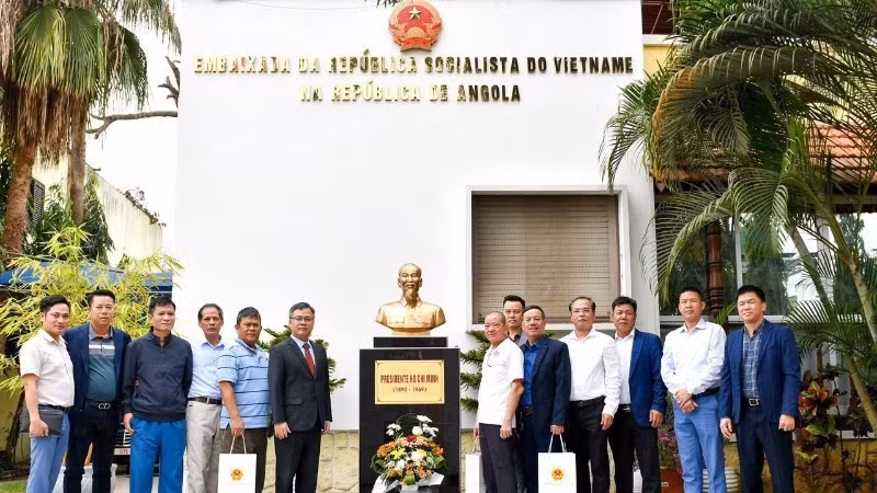 El embajador Duong Chinh Chuc y veteranos de guerra vietnamitas en Angola posan para una fotografía junto al busto al Presidente Ho Chi Minh, en el recinto de la embajada. (Foto: Embajada de Vietnam en Angola)