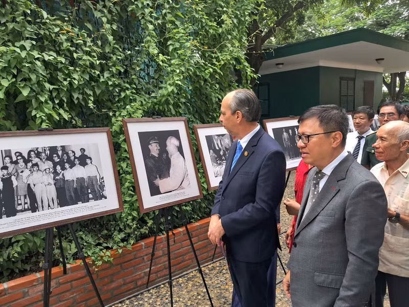 El presidente-editor del periódico Nhan Dan, subjefe de la Comisión de Propaganda y Educación y presidente de la Asociación de Periodistas de Vietnam, Le Quoc Minh, y el embajador cubano en Hanói, Rogelio Polanco Fuentes, visitan la exposición de fotografías y de documentos históricos. (Foto: Embajada de Cuba en Vietnam).