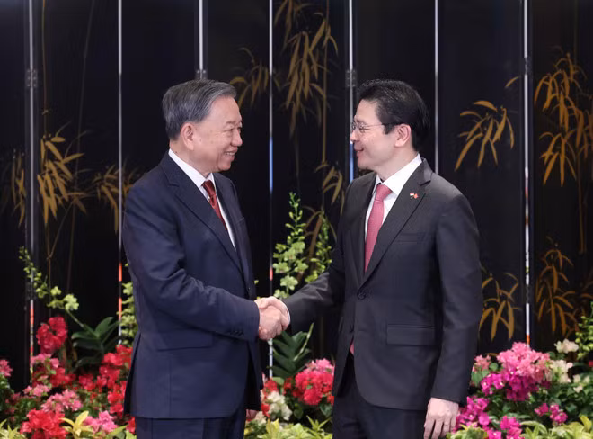 El secretario general del PCV, To Lam (izq.), y el primer ministro Lawrence Wong (der.). (Foto: VNA)