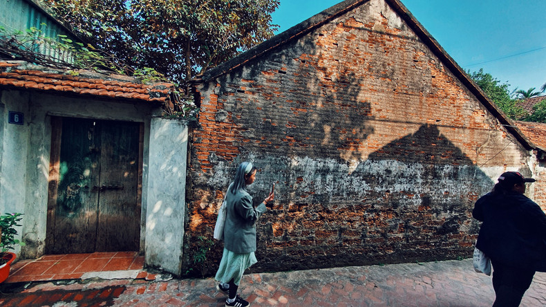 Los turistas visitan a la aldea en días previos del Tet.