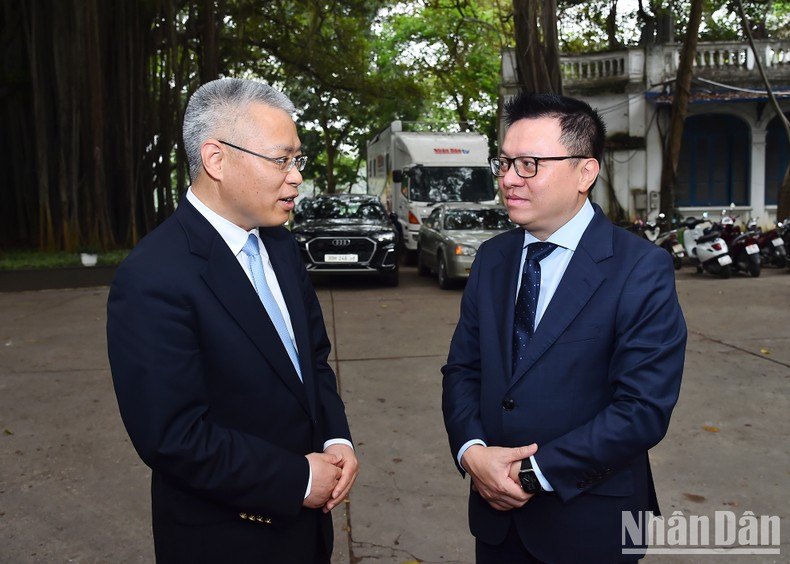 Quoc Minh y Hu Zhaoming conversan después de la reunión.