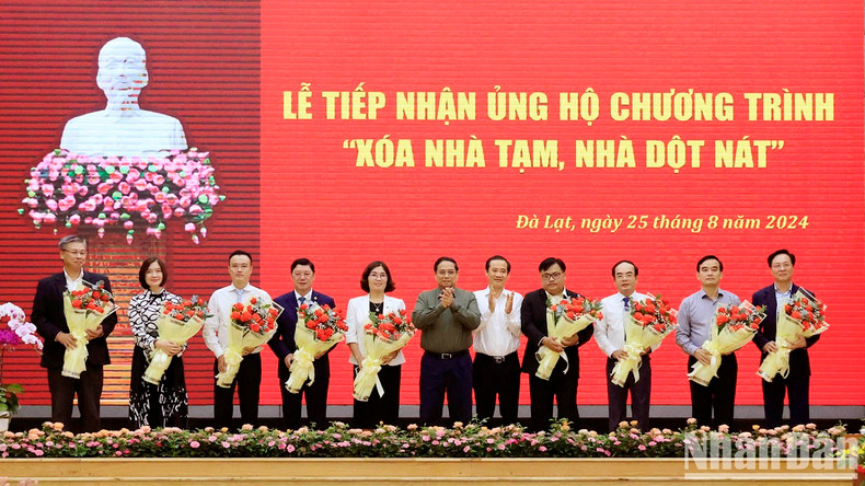 Minh Chinh y el secretario interino del Comité del Partido en Lam Dong, Nguyen Thai Hoc, entregan flores para agradecer a los patrocinadores.