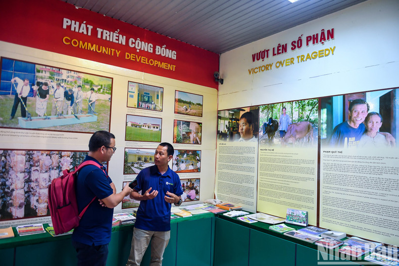 Un guía turístico del museo presenta a los periodistas del periódico Nhan Dan ejemplos del tema "Superar el destino".