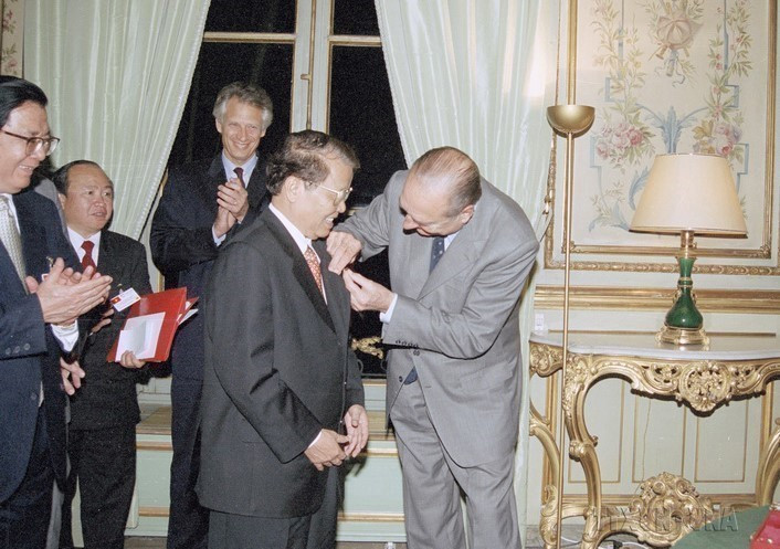 El presidente francés, Jacques Chirac, confiere la Orden Nacional de la Legión de Honor a su homólogo vietnamita, Tran Duc Luong, en París, el 28 de octubre de 2002.