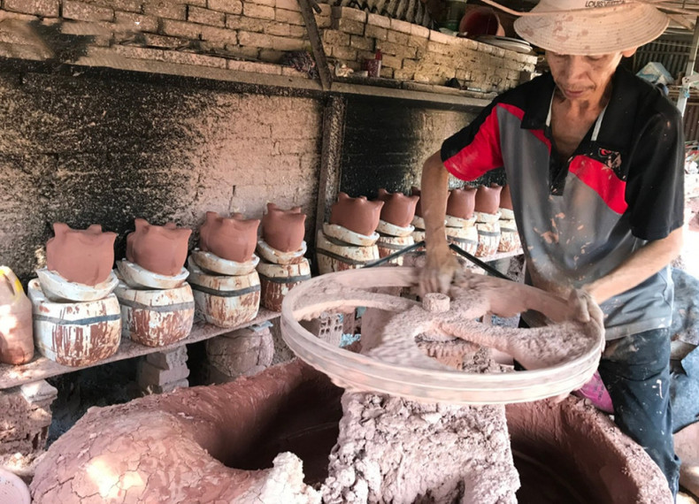 Los trabajadores en los hornos alfareros de Binh Duong están ocupados mezclando la arcilla.