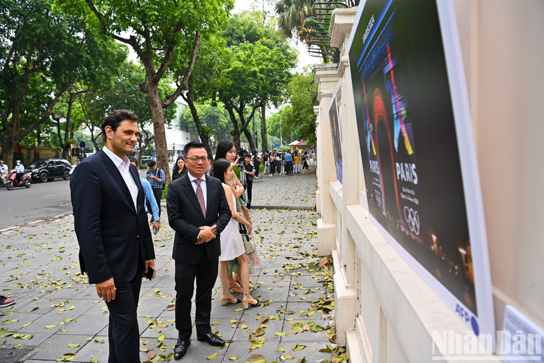 El presidente-editor del periódico Nhan Dan, Le Quoc Minh y otros delegados visitan la exposición.