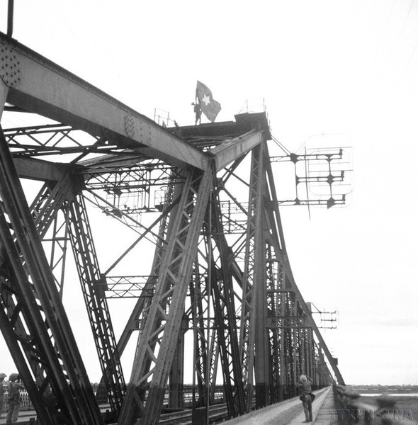 Un soldado coloca la bandera de la liberación en el puente Long Bien.