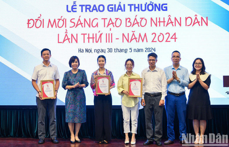 Tran Thi Kieu Thanh Binh, presidenta del Sindicato de periódico Nhan Dan, y Le Khanh Binh, secretaria del Sindicato del rotativo, entregan premios a los equipos con presentaciones impresionantes.
