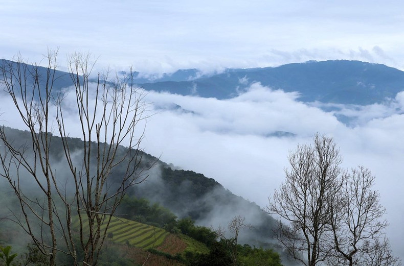 Las blancas nubes cubren los campos de terrazas que se entrelazan con majestuosas montañas.