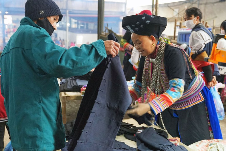 Los pobladores de la minoría étnica de Dao venden trajes en el Mercado de Meo Vac.