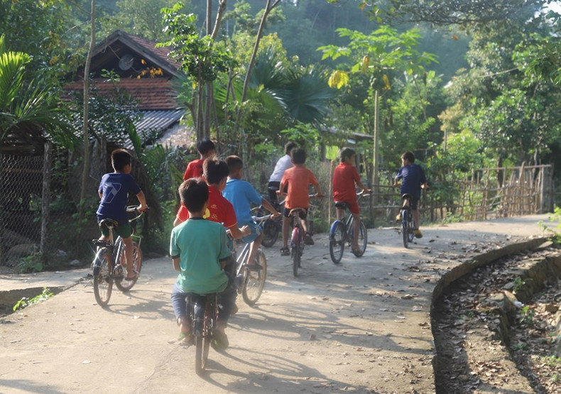 Los niños de las etnias de O Du, Kho mu y Thai andan en bicicleta en la aldea de Vang Mon.