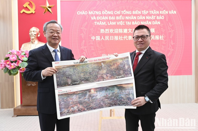 Quoc Minh entrega a Chen Jianwen el suplemento Campaña de Dien Bien Phu de la publicación escrita de Nhan Dan.