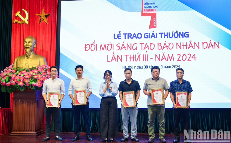 Phan Thanh Phong, jefa de la Redacción Nhan Dan Mensual y vicepresidenta de la Asociación de Periodistas del periódico Nhan Dan, entrega premios de consolación a los grupos de autores.