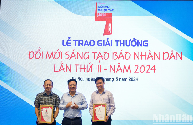 Que Dinh Nguyen, vicesecretario del Comité del Partido y redactor subjefe del periódico Nhan Dan, entrega los premios B a los grupos de autores.