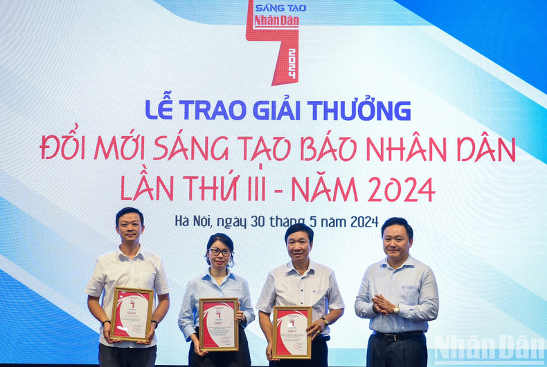Phan Van Hung, miembro del Comité Permanente del Comité del Partido y redactor subjefe del periódico Nhan Dan, entrega los premios C a los grupos de autores.