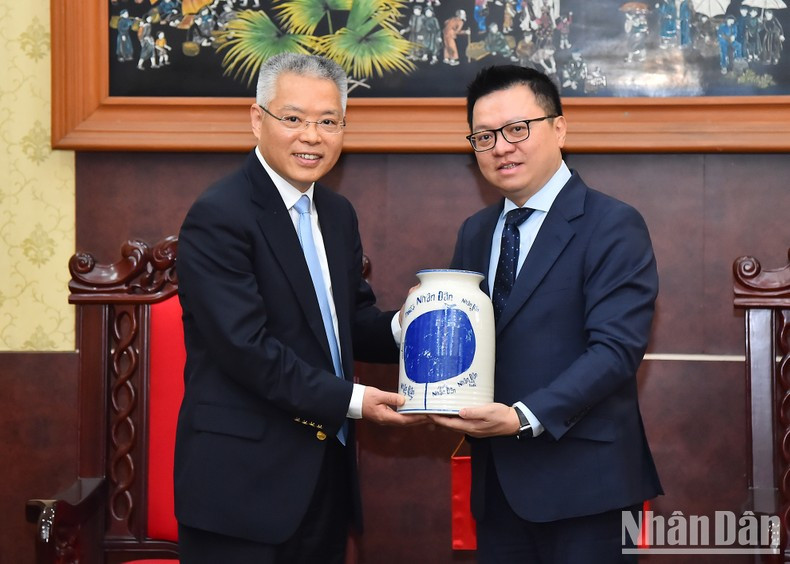 Quoc Minh entrega un obsequio al visitante chino.
