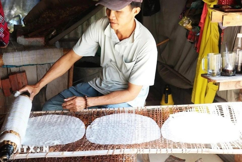 Nguyen Van Tai, de la aldea de Hau Thuan, comuna de Hau Thanh, coloca los panqueques de arroz recién cocinados en una estela para secarlo.