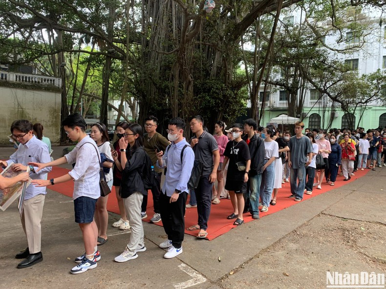 Los visitantes esperan en largas colas para recibir la versión en papel de dicha pintura. Los visitantes esperan en largas colas para recibir la versión en papel de dicha pintura.