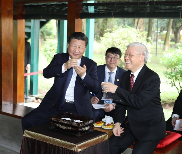 El secretario general Nguyen Phu Trong y el secretario general del Partido Comunista y presidente de China, Xi Jinping, disfrutan el té en la Casa sobre pilotes en la zona conmemorativa del Presidente Ho Chi Minh, el 13 de noviembre de 2017 en Hanói. Foto: Tri Dung - VNA
