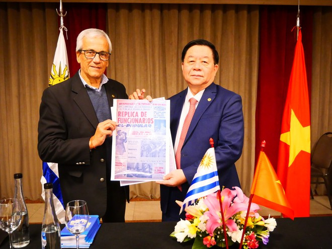 El secretario general del Partido Comunista de Uruguay, Juan Castillo, entrega a Nguyen Trong Nghia una copia del artículo que un periodista de El Popular entrevistó al tío Ho publicado el 3 de diciembre de 1965. (Foto: VNA) El secretario general del Partido Comunista de Uruguay, Juan Castillo, entrega a Nguyen Trong Nghia una copia del artículo que un periodista de El Popular entrevistó al tío Ho publicado el 3 de diciembre de 1965. (Foto: VNA)