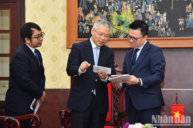 Quoc Minh y Hu Zhaoming intercambian opiniones al margen de la reunión.