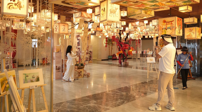 El espacio de exhibición de arte popular en la montaña Ba Den, decorado con faroles pintados a mano y cuadros tradicionales, cautiva a los visitantes que buscan capturar recuerdos fotográficos. El espacio de exhibición de arte popular en la montaña Ba Den, decorado con faroles pintados a mano y cuadros tradicionales, cautiva a los visitantes que buscan capturar recuerdos fotográficos.