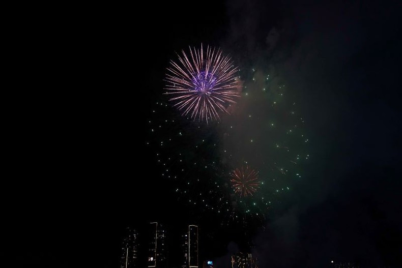 Los fuegos artificiales iluminan el cielo nocturno de la ciudad.