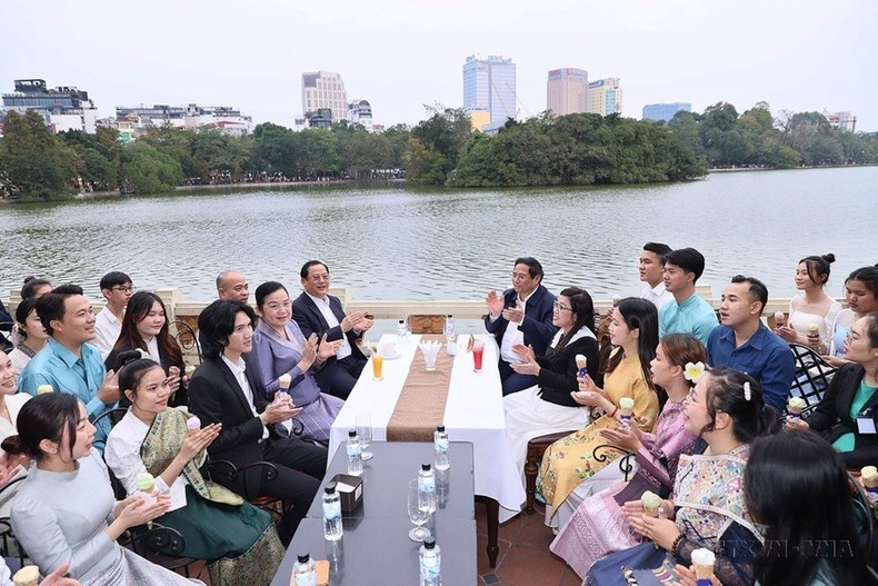 El primer ministro Pham Minh Chinh y su esposa, el premier Sonexay Siphandone y su esposa, junto con los estudiantes, cantan la canción de solidaridad entre Vietnam y Laos en el espacio cultural e histórico del lago Hoan Kiem (7 de enero de 2024).