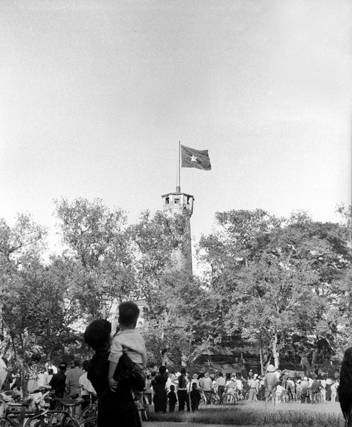 Los pobladores miran con orgullo y alegría a la Torre de la Bandera de Hanói y la insignia nacional.