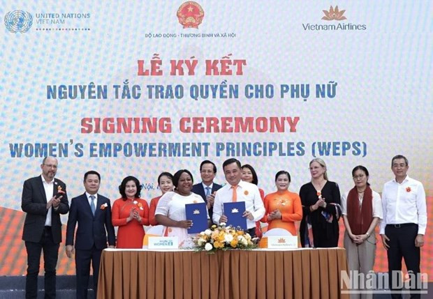 Le Duc Canh, director general adjunto de Vietnam Airlines y Caroline Nyamayemombe, representante principal interina de ONU Mujeres, firman un compromiso de participar en actividades basadas en principios para empoderar a las mujeres.