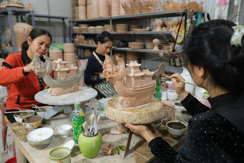 Aplicando esmalte sobre la cerámica &quot;Ngu long khanh hoi&quot; en el taller del artesano Nguyen Trong Nghia en el pueblo de cerámica Bat Trang.