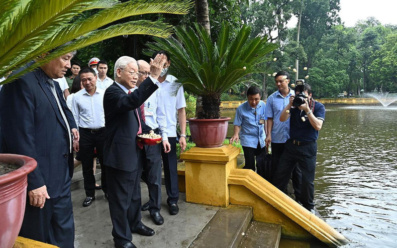 Phu Trong alimenta a los peces en el estanque en la Zona de Reliquias.