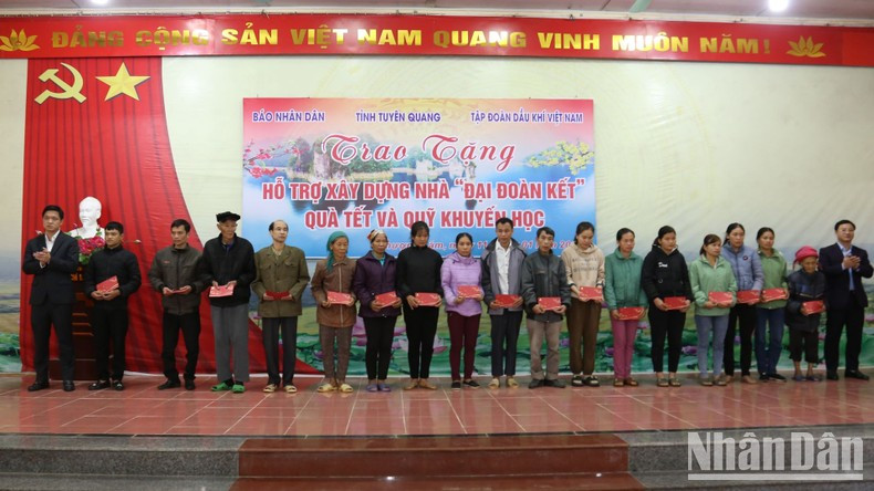 Representantes del periódico Nhan Dan y del Grupo Petrovietnam entregan obsequios a hogares con pocos recursos económicos.