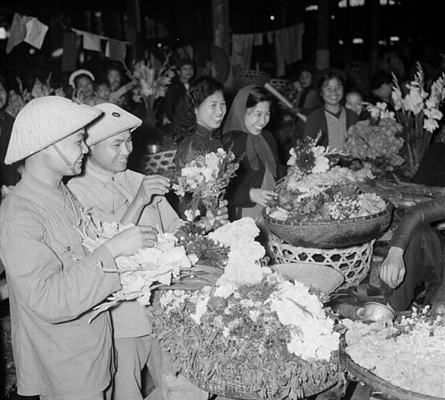 Soldados y personas compran flores. (Fotografía: VNA)