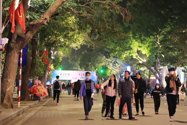 En la calle Dinh Tien Hoang, las familias esperan el momento de entrar en el año 2023.