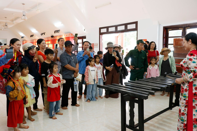 Visitantes disfrutando de una presentación de litófono en el espacio expositivo de Bom Bo.