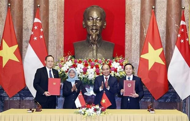 La presidenta singapurense Halimah Yacob y el jefe de Estado vietnamita, Nguyen Xuan Phuc, presenciaron la firma de memorandos de entendimiento de la cooperación binacional. (Foto: VNA) La presidenta singapurense Halimah Yacob y el jefe de Estado vietnamita, Nguyen Xuan Phuc, presenciaron la firma de memorandos de entendimiento de la cooperación binacional. (Foto: VNA)