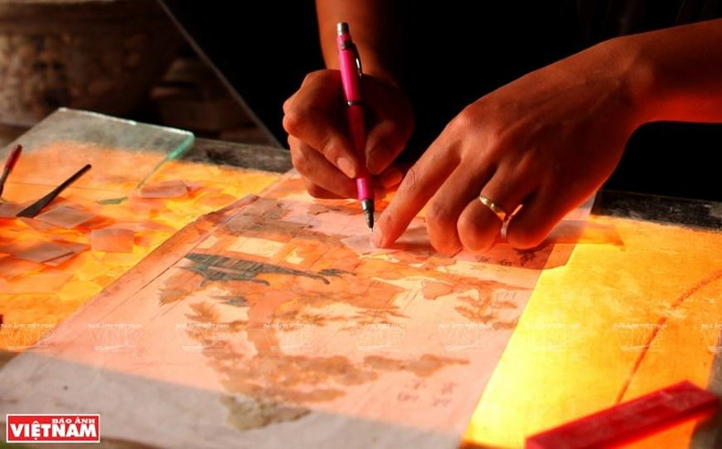 Los creadores dibujan prototipos en papel antes de tallar en madera. (Foto: VNA) Los creadores dibujan prototipos en papel antes de tallar en madera. (Foto: VNA)