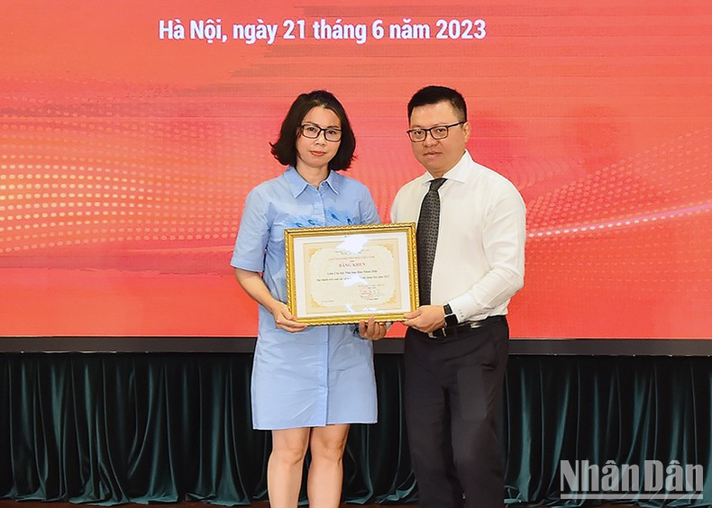 Una representante del colectivo recibe el certificado de mérito de la APV.