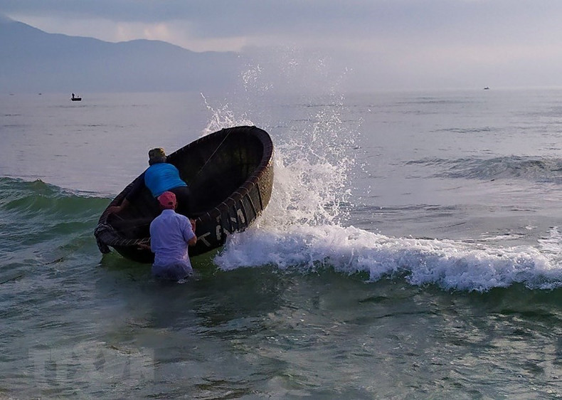 Pescadores avanzan hacia el mar para lanzar sus redes.
