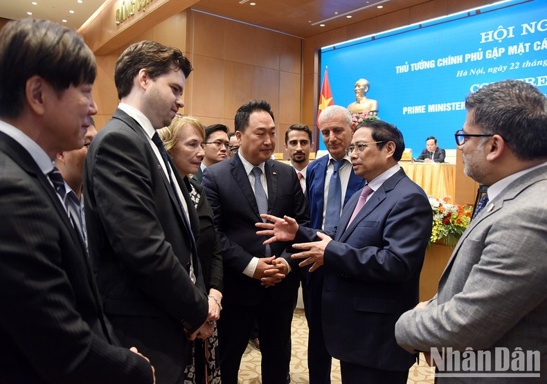 El primer ministro Pham Minh Chinh conversa con inversionistas al margen de la reunión. El primer ministro Pham Minh Chinh conversa con inversionistas al margen de la reunión.